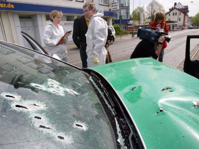 Politie en pers aanschouwen de auto na de aanhouding.  dpa