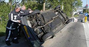 Hulpverleners proberen een gelanceerde auto weer op zijn wielen te zetten.