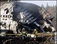 Reddingswerkers staan bij het vliegtuigwrak